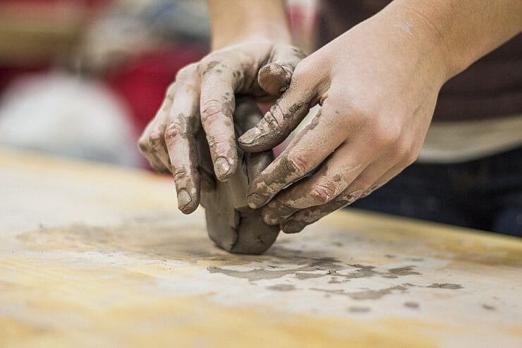 Artist's hands moulding clay