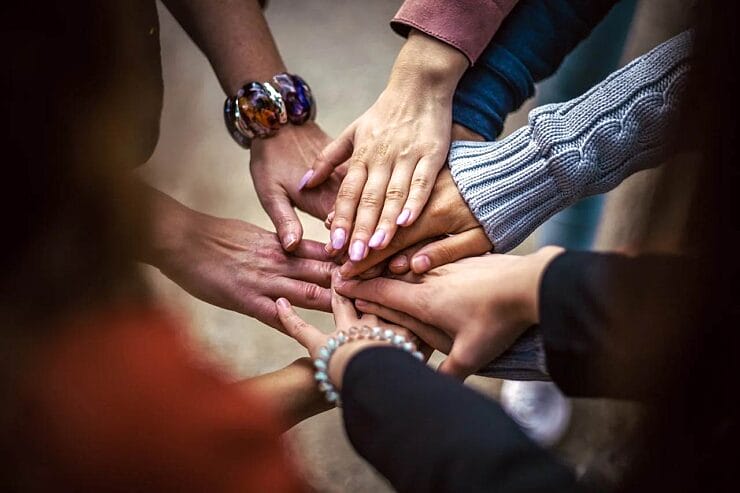 People linking hands in a circle